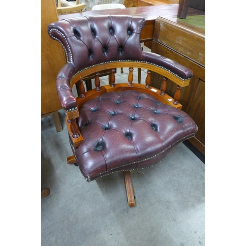 136 - A beech and burgundy leather revolving captain's desk chair