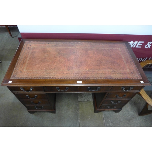 27 - A George III style mahogany and red leather topped pedestal desk