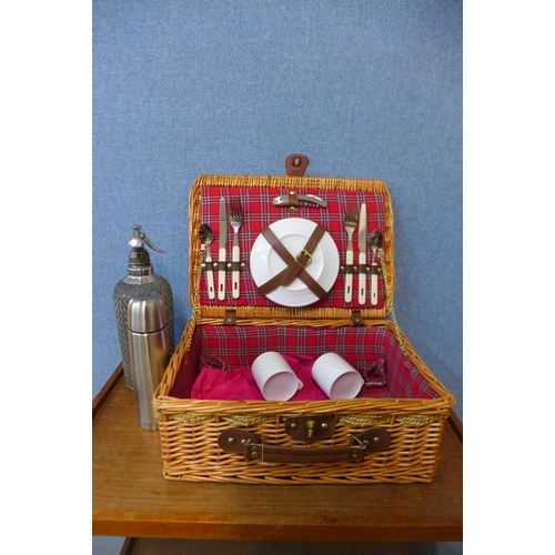 394 - A wicker picnic basket, containing cutlery, a flask and a soda dispenser