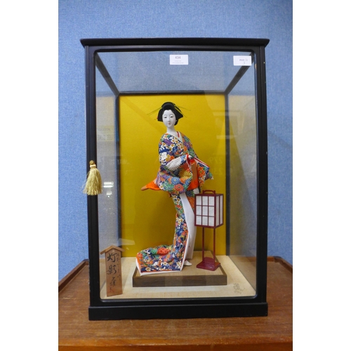 434 - A Japanese model of a Geisha girl, in a glass display case