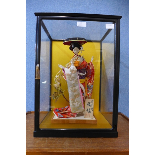 435 - A Japanese model of a Geisha girl, in a glass display case