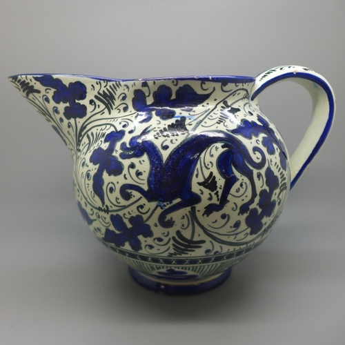 616 - A 19th Century jug, with blue and white mythical beast decoration, 17cm, hairline crack inside jug