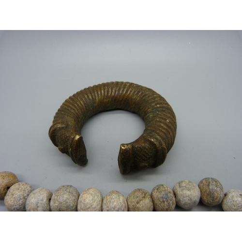 620 - A fossilised mammoth bone necklace and a bronze bangle