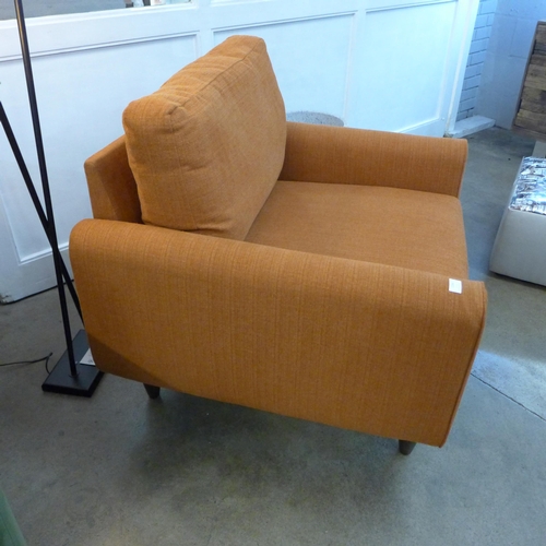 1334 - A designer burnt orange upholstered armchair