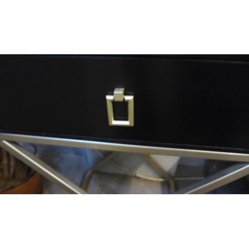 1354 - A black single drawer bedside chest with gold cross legs (marked)