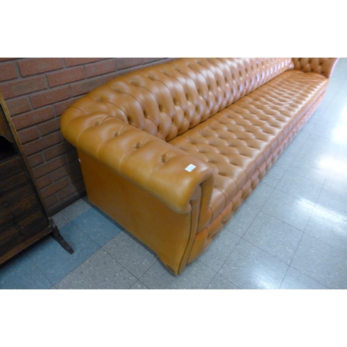 11 - An extremely large tan leather Chesterfield settee, 72cms h, 345cms w, 90cms d