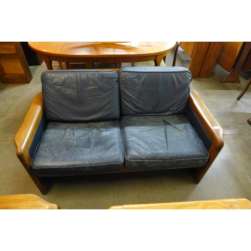 103 - A Danish Dyrlund teak and blue leather settee, armchair and a coffee table