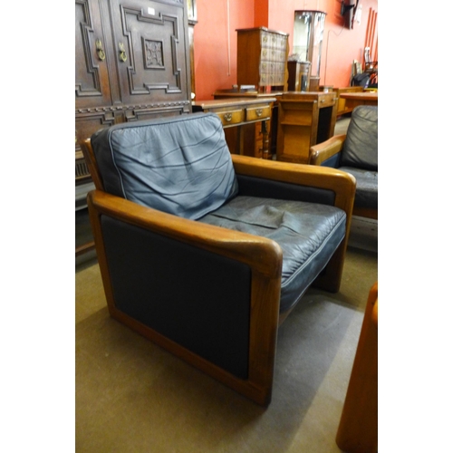 103 - A Danish Dyrlund teak and blue leather settee, armchair and a coffee table