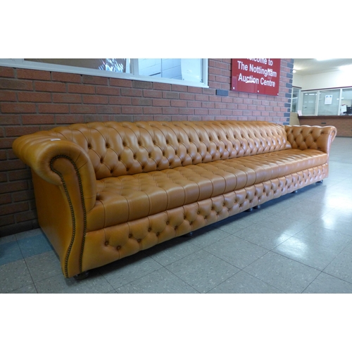 11 - An extremely large tan leather Chesterfield settee, 72cms h, 345cms w, 90cms d