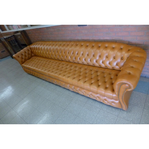 11 - An extremely large tan leather Chesterfield settee, 72cms h, 345cms w, 90cms d