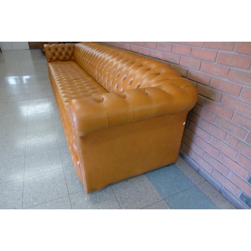 11 - An extremely large tan leather Chesterfield settee, 72cms h, 345cms w, 90cms d