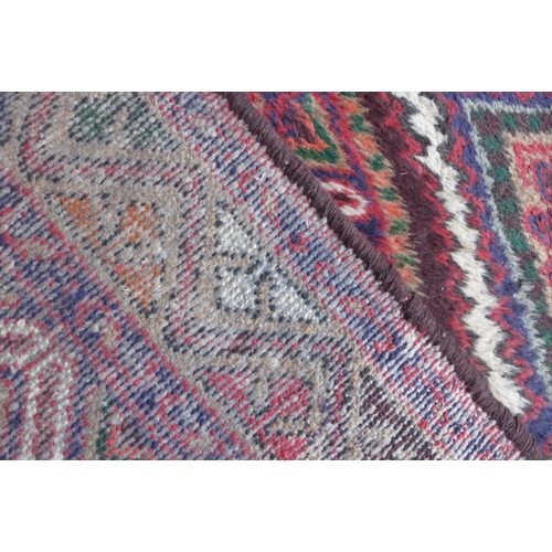 142 - An eastern red ground runner rug, 297 x 77cms