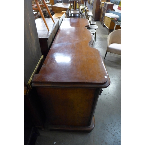 217 - An early Victorian mahogany serpentine pedestal sideboard