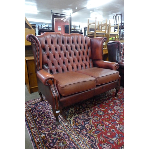 26 - A red leather Chesterfield wingback settee