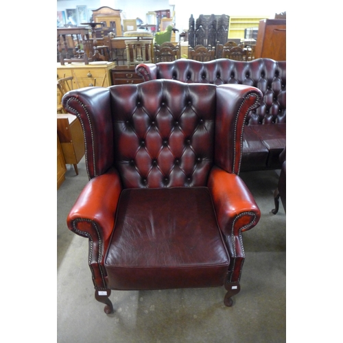 28 - A red leather Chesterfield wingback armchair