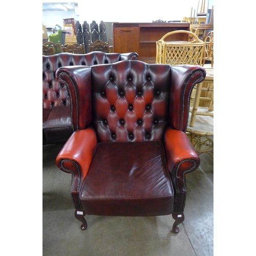 29 - A red leather Chesterfield wingback armchair