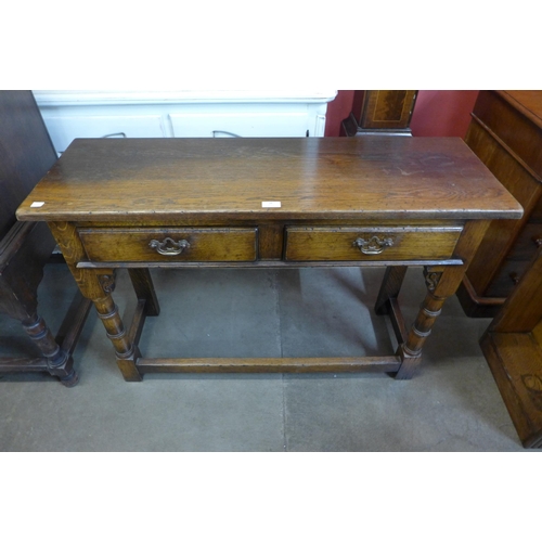 38 - A George III style oak two drawer side table