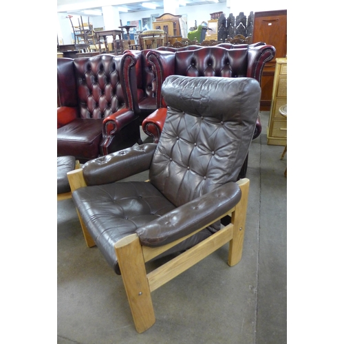 87 - A Scandanavian light ash and brown leather armchair and footstool