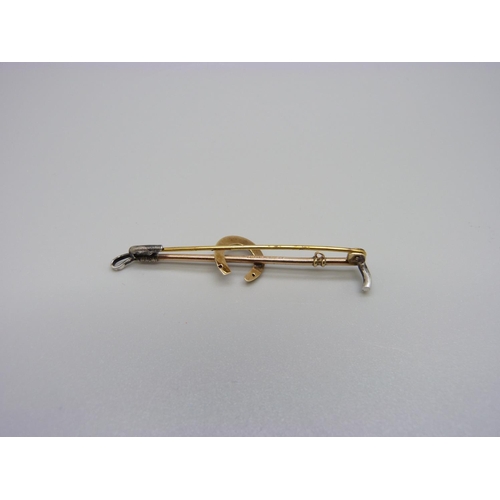 1008 - A 9ct gold and silver horseshoe and whip brooch, 2.6g