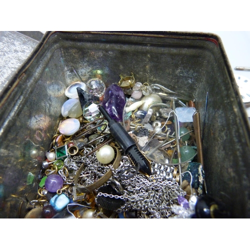 970 - A tin of jewellery, gemstone oddments, etc.