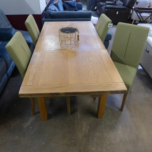 1360 - An oak extending dining table and a set of four green fabric dining chairs