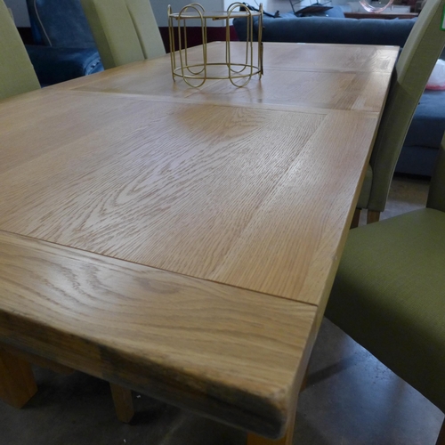 1360 - An oak extending dining table and a set of four green fabric dining chairs