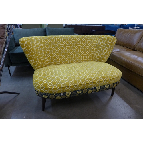 1365 - A marigold velvet and floral patterned upholstered two seater sofa