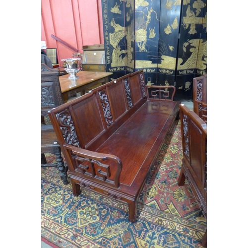 41 - A Chinese carved hardwood settee and a pair of armchairs