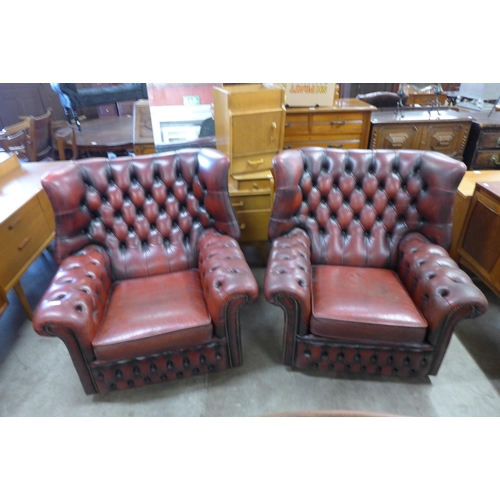 170 - A pair of oxblood red leather Chesterfield wingback armchairs