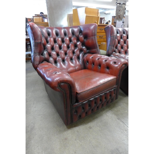 170 - A pair of oxblood red leather Chesterfield wingback armchairs