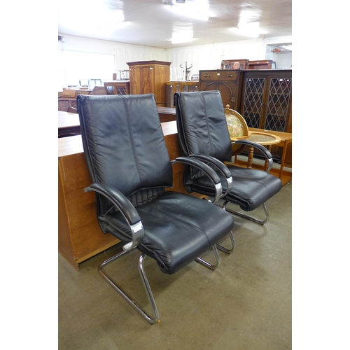 66 - A pair of black leather and chrome armchairs