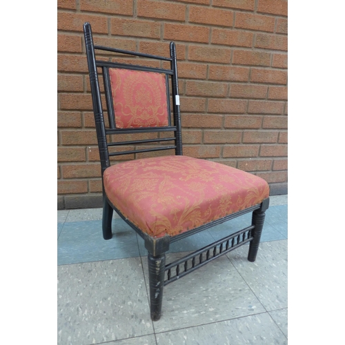 8 - An Arts and Crafts ebonised fire side chair, manner of E.W. Godwin