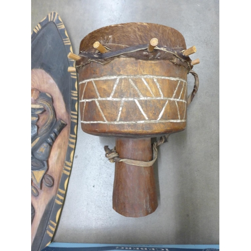 1143 - An African tribal wooden figure, carvings, shields, bongo drum, etc.**PLEASE NOTE THIS LOT IS NOT EL... 