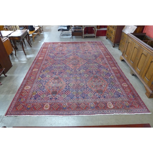 162 - A large Persian hand knotted red ground Sanandaj rug, 394 x 275cms