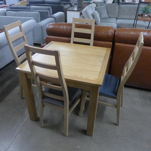 1413 - A large square oak dining table with a set of four fabric seat and oak dining chairs - one odd seat ... 