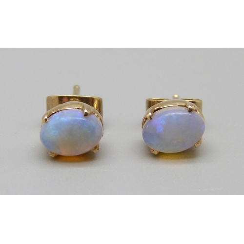 1087 - A pair of yellow metal and opal stud earrings