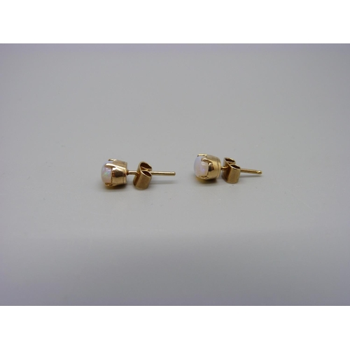 1087 - A pair of yellow metal and opal stud earrings