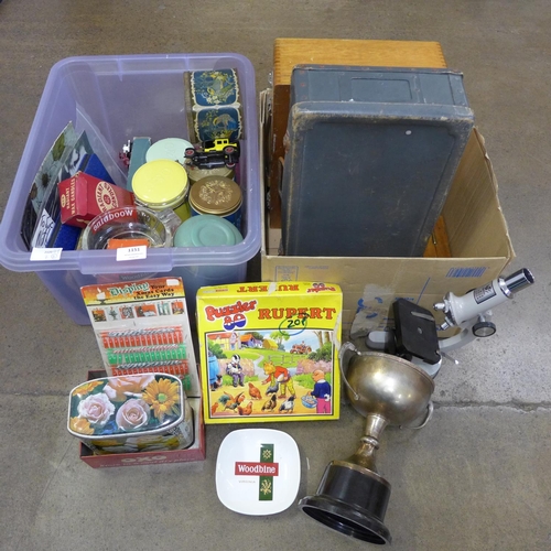 1151 - A microscope, plated trophy, shoe pull, a box of slides, case, a box of tins, advertising items, Rup... 