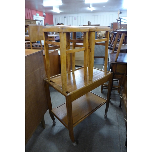 122 - A teak single drawer trolley and a pair of beech stools