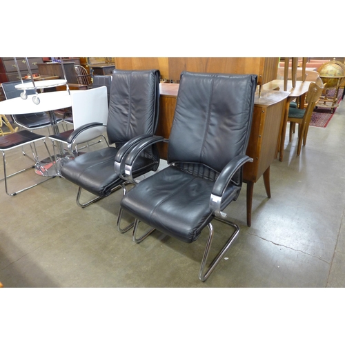 129 - A pair of black leather and chrome armchairs