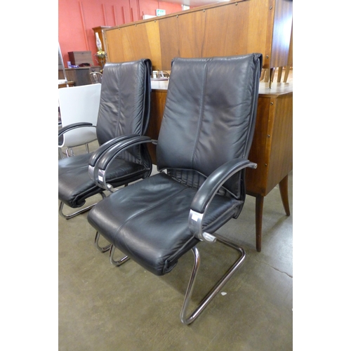 129 - A pair of black leather and chrome armchairs