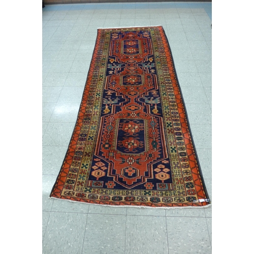 163 - An eastern red ground rug, 320 x 123cms