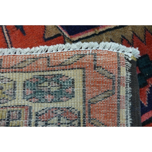 163 - An eastern red ground rug, 320 x 123cms