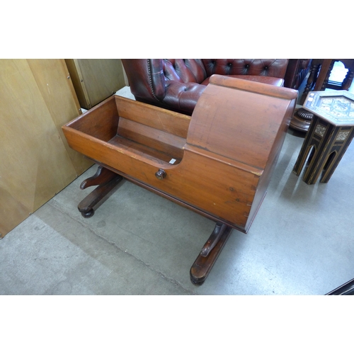 216 - A Victorian stained pine child's cot on stand