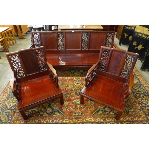 222 - A Chinese carved hardwood settee and a pair of armchairs