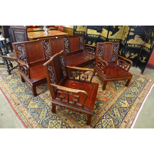 222 - A Chinese carved hardwood settee and a pair of armchairs