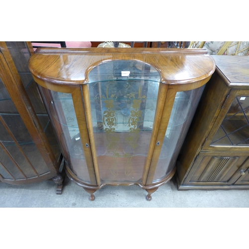 247 - A walnut serpentine display cabinet