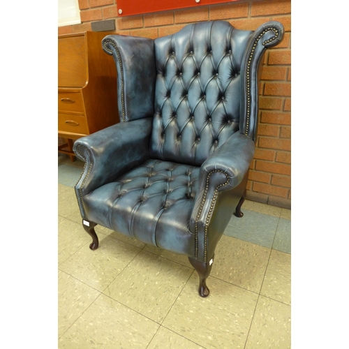 26 - A mahogany and blue leather Chesterfield wingback armchair