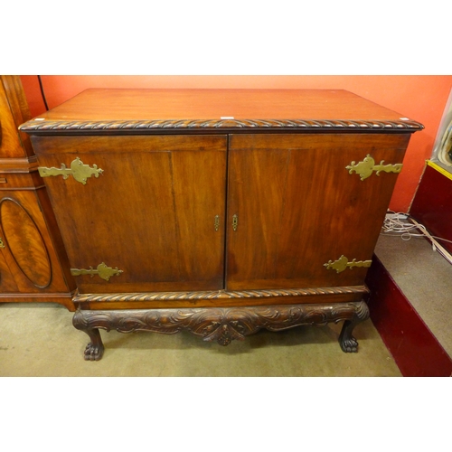 27 - A Chippendale Revival carved mahogany press cupboard on a stand