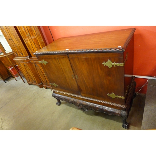 27 - A Chippendale Revival carved mahogany press cupboard on a stand